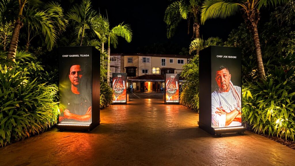 Illuminated entrance to the Casa de Campo Food & Wine Festival with banners featuring chefs Gabriel Tejada and Joe Isidori.