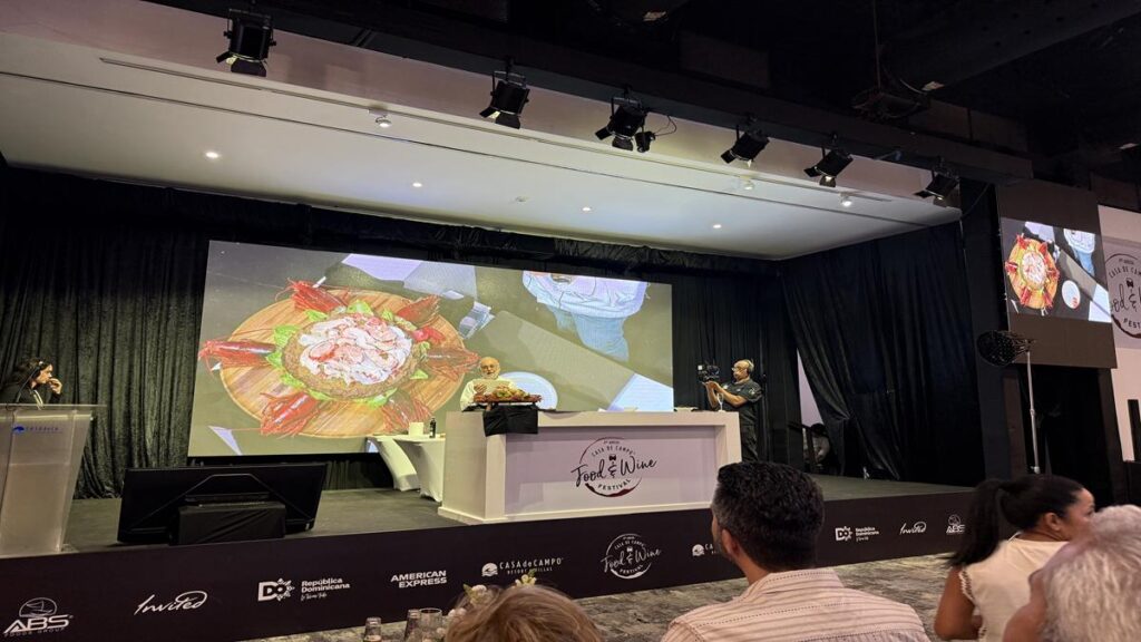 Celebrity chef presenting a dish on the main stage of the Grand Tasting Pavilion