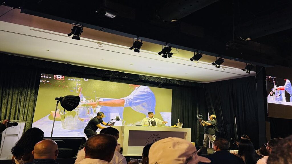 Live cooking demonstration on the main festival stage with a large screen and cameras