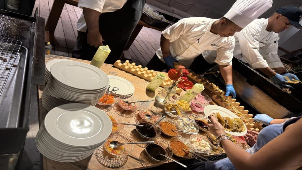 Chefs preparing tacos with different toppings and sauces at Dinner Under the Stars