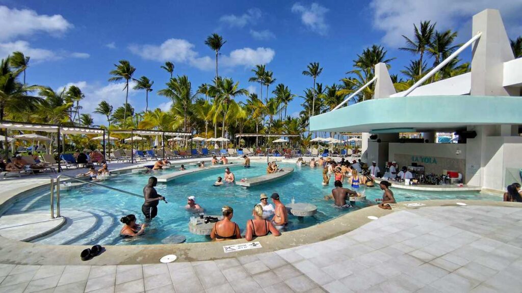 Outdoor pool area surrounded by palm trees at Riu Palace Bavaro