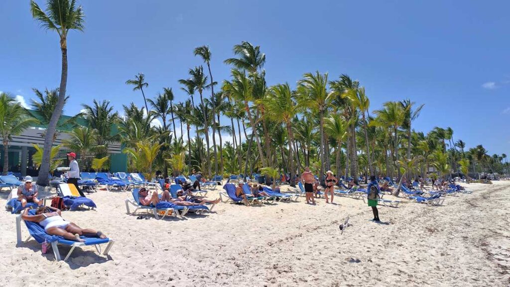 A typical day at Riu Bambu Beach with lounge chairs, a vendor, and sunny weather
